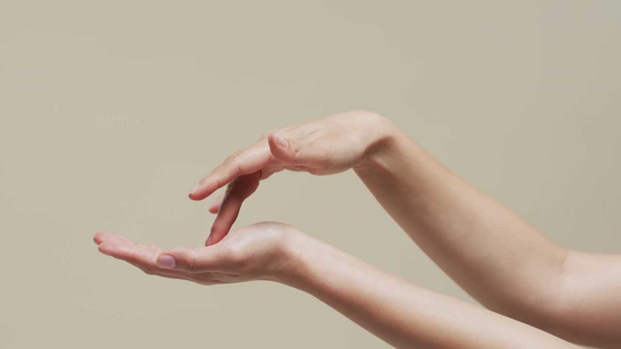 복사 공간과 베이지색 배경에 있는 아시아 여성의 손, 슬로우 모션