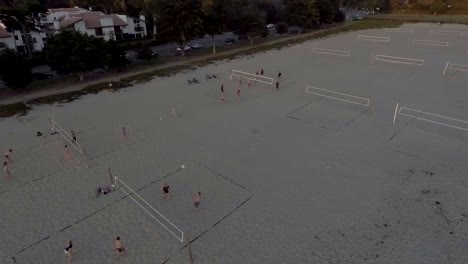 grupos de amigos jugando voleibol de playa