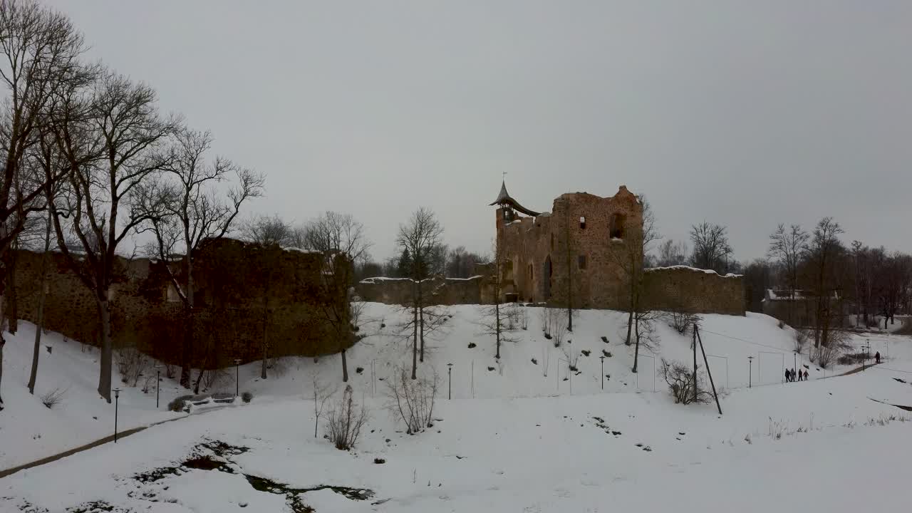 Ruins of Ancient Livonian Order's Stone Medieval Castle Latvia Aerial Drone Top Shot From Above . Restored Castle Capella at Winter in Dobele City. 4K Resolution. Camera Moves Upward