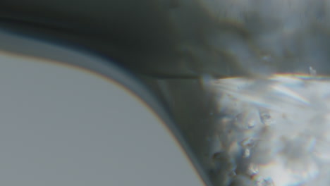 white transparent fluid with small crystals inside moving slowly