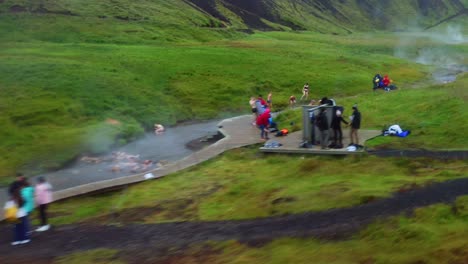 fly fast over people on natural bath in reykjadalur hot springs near hveragerdi, iceland