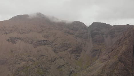Drone-shot-turning-to-the-right-in-mountain-landscape-in-isle-of-skye-highlands-scotland,-Cloudy-day
