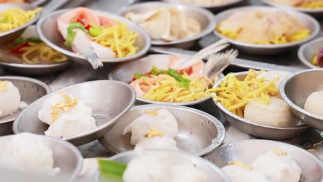 una vibrante exhibición de platos de dim sum en un bullicioso mercado de phuket, mostrando una variedad de selecciones coloridas y apetitosas