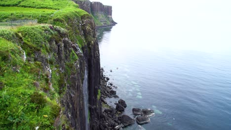 Wasserfall-über-Die-Grüne-Klippe-Hinunter-In-Die-Mehlfälle-In-Das-Klare-Blaue-Wasser,-Während-Ein-Vogel-Davonfliegt