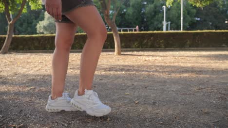 Vista-De-ángulo-Bajo-De-Las-Piernas-De-Una-Mujer-Caminando-Por-Un-Parque