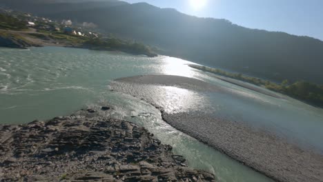 aerial dynamic view speed water flow mountain river cliff rocky texture island and walking bridge