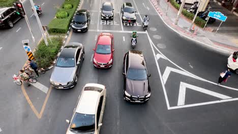 vehicles and motorcycles navigating a busy intersection