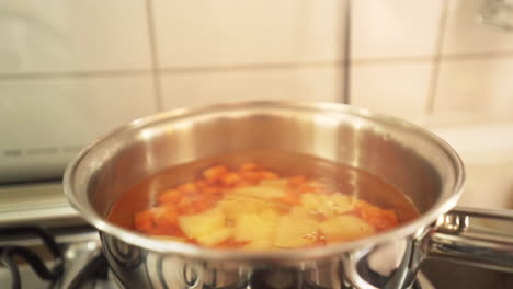 pooring chopped potatoes in the boiling pan