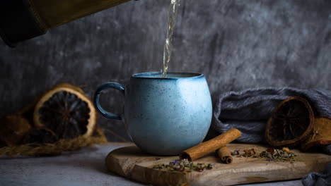 pouring tea in blue vintage cup on moody background