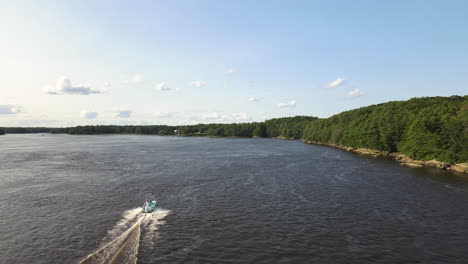 drone chase shot of a speed boat on the kennebec river in maine