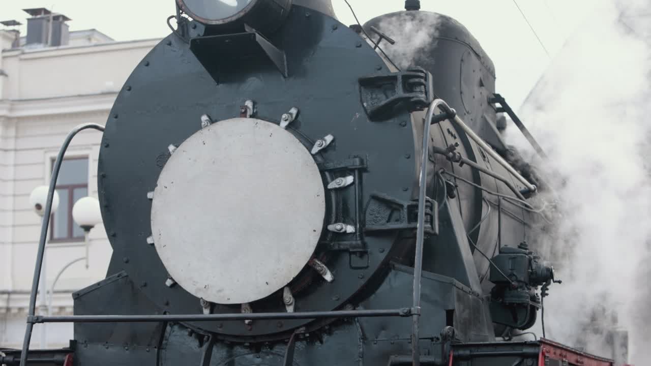 화물 마당을 통과하는 역에 접근하는 증기 기관차 열차