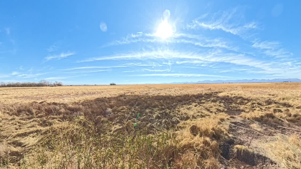 Rotating Time lapse of blue skies in Arizona over dry grasslands.
