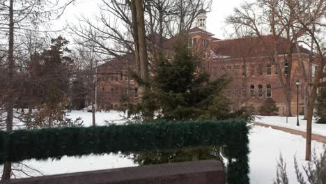 Main-sign-of-University-of-Wisconsin-Stevens-Point-during-winter,-aerial-revealing-campus-building