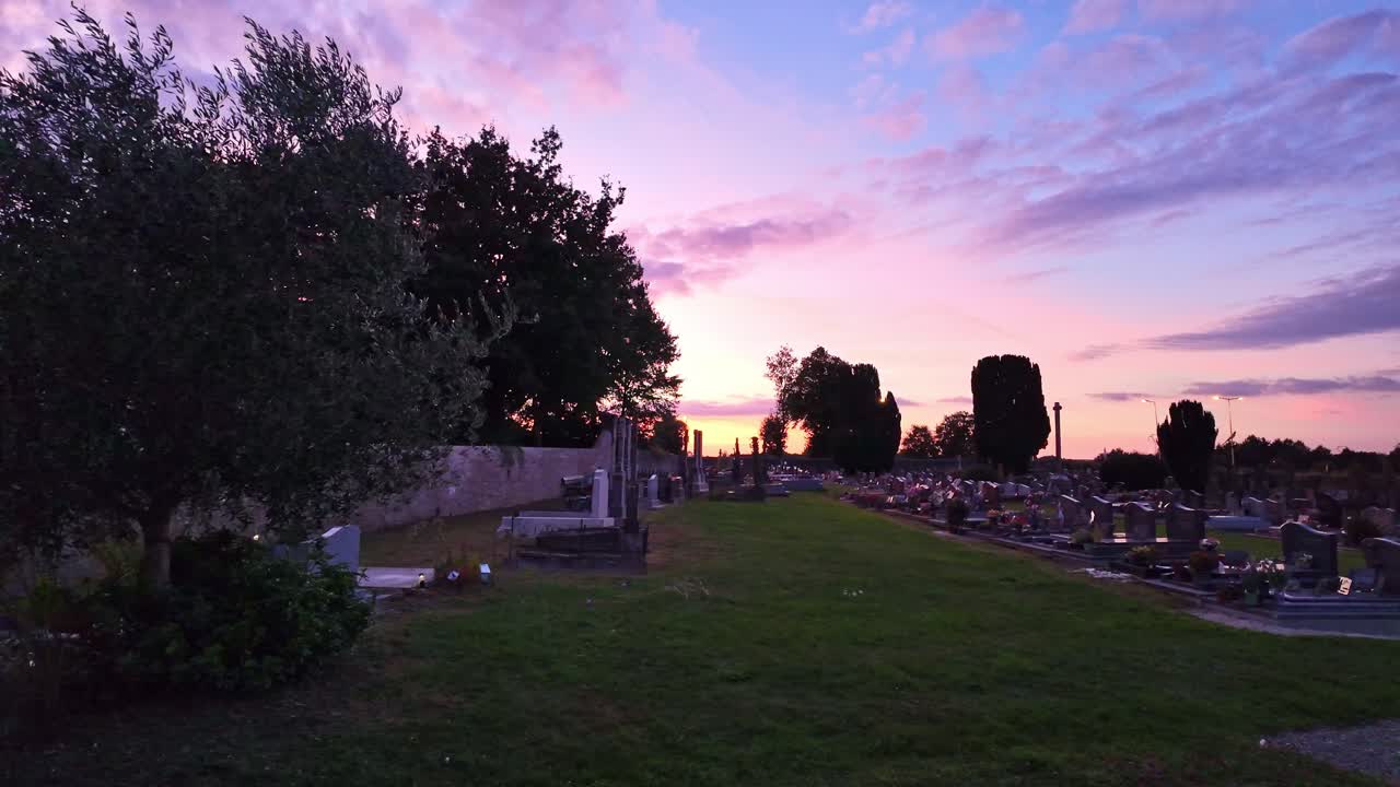 Cemetery at sunset with colorful pink violet sky, France