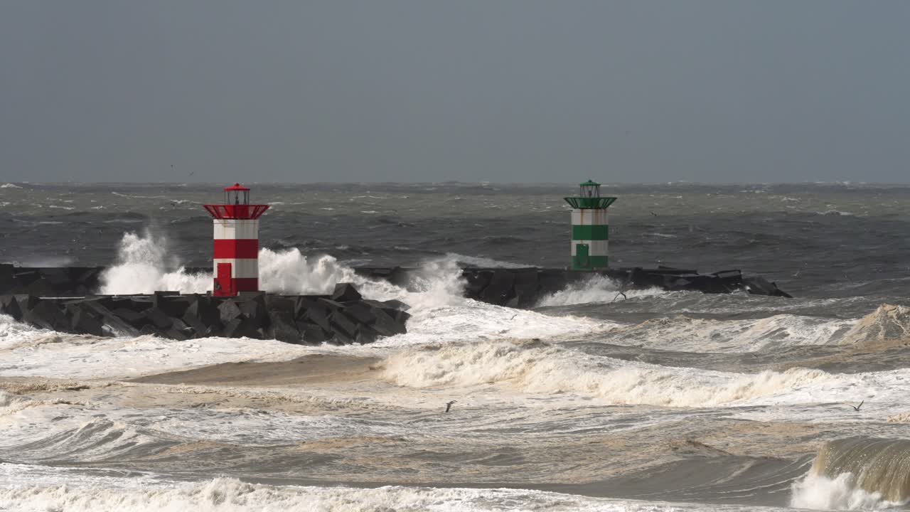 grandes olas de clima extremo que golpean el faro holandés en el muelle rocoso
