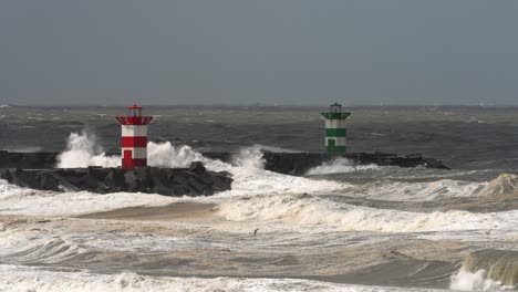 large extreme weather waves hitting dutch lighthouse on rocky pier