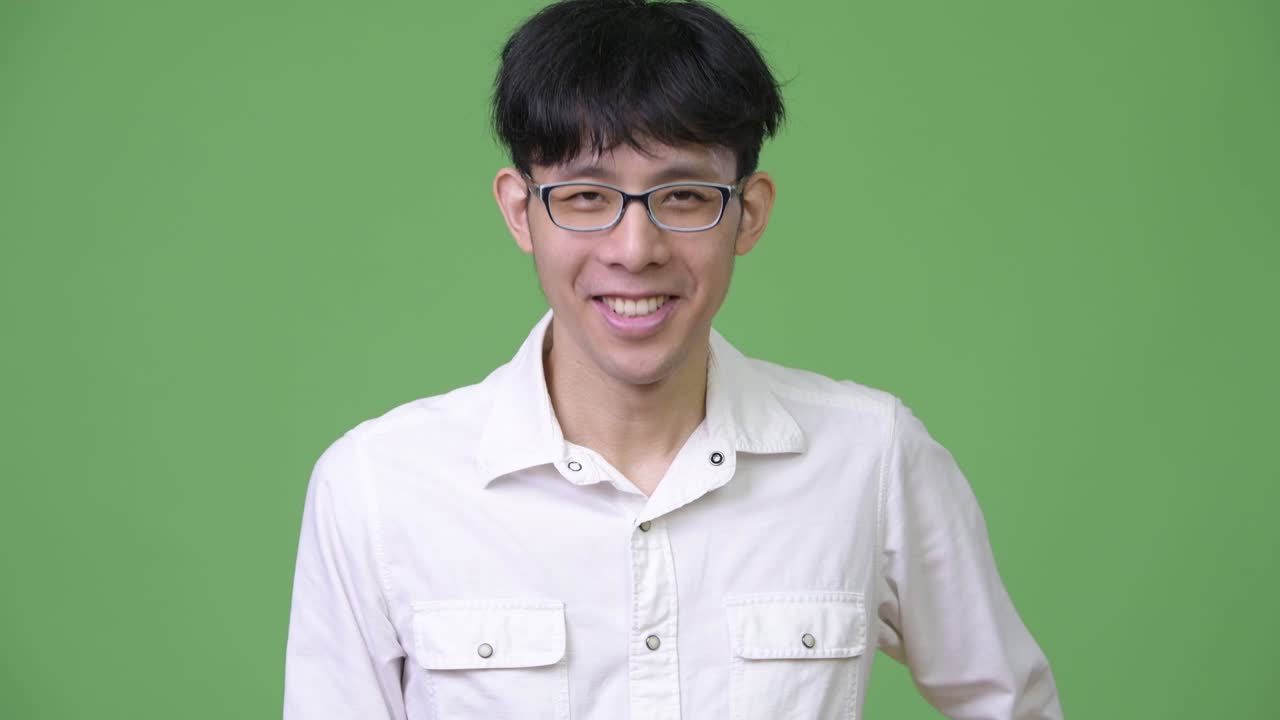 행복한 젊은 아시아 사업가 머리를 흔들고