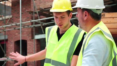 Baumeister-Auf-Der-Baustelle-Diskutiert-Arbeit-Mit-Lehrling