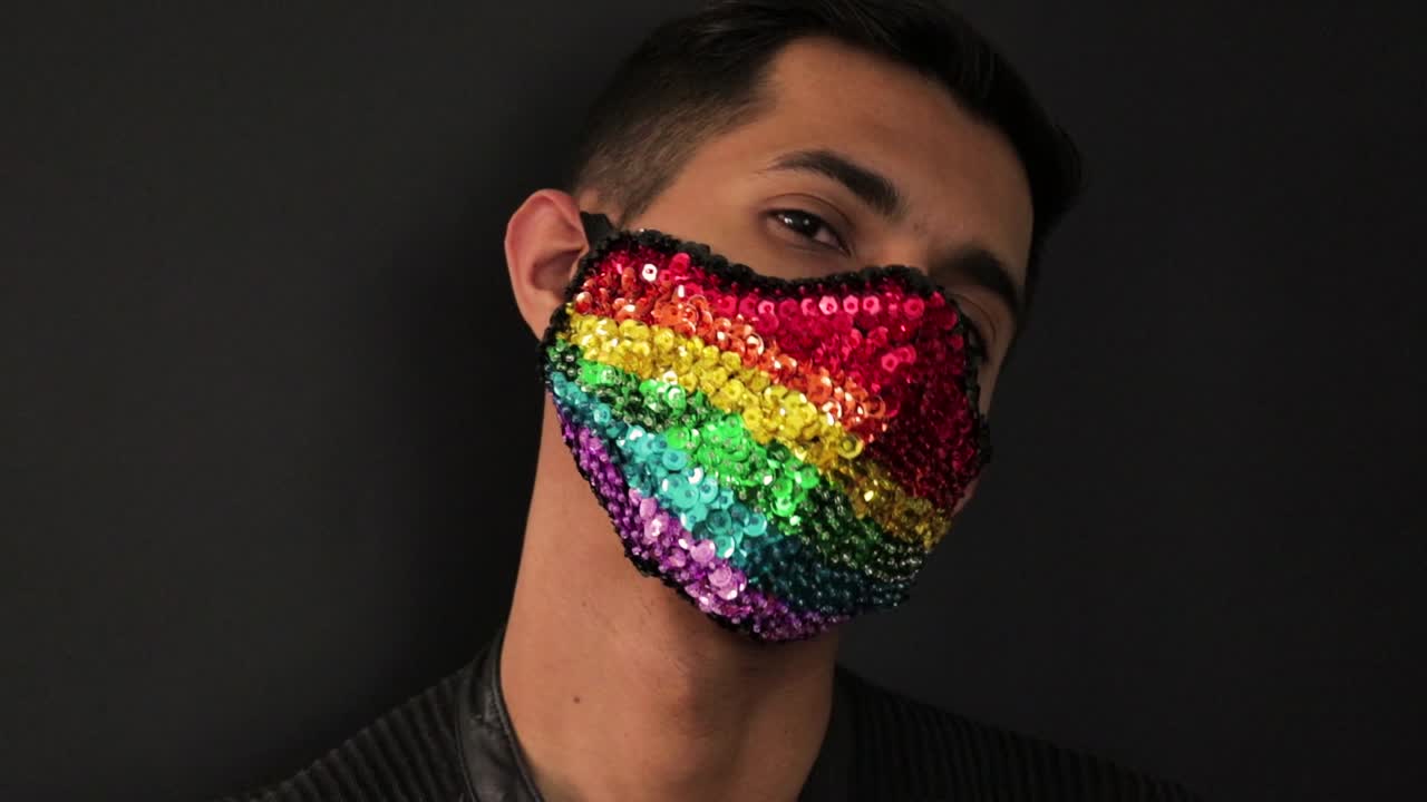 modelo hispana con una máscara facial de lentejuelas arcoíris