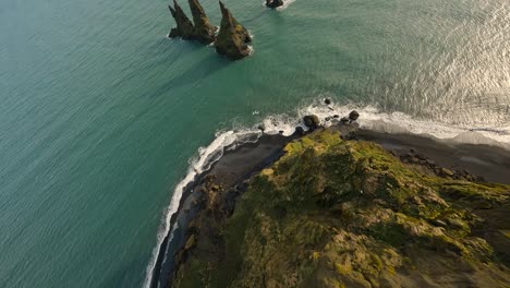 buceo aéreo fpv disparado por un acantilado hacia las pilas de mar de basalto reynisdrangar