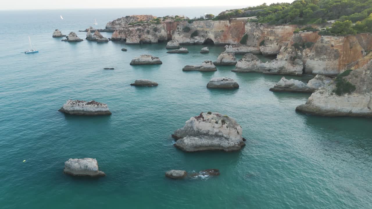 A breathtaking aerial view of the Alvor cliffs and serene ocean waters. Push Forward Shot