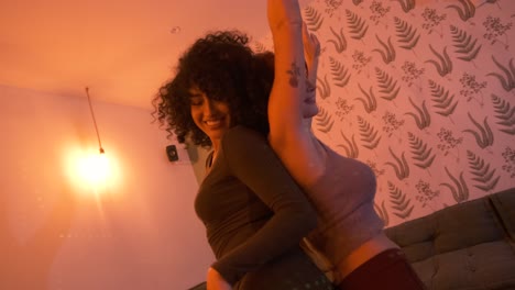 smiling diverse girlfriends dancing back to back