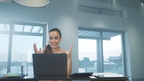 happy business woman receiving good news on laptop computer at home