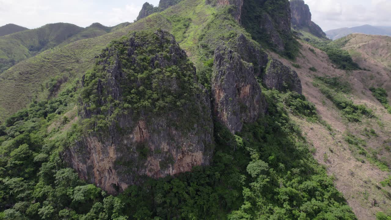 Papelon Morro at the "Aristides Rojas" Natural Monument, in Guarico state, Venezuela of a rugged, rocky mountain peak covered in green foliage