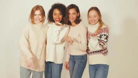 four women in winter sweaters