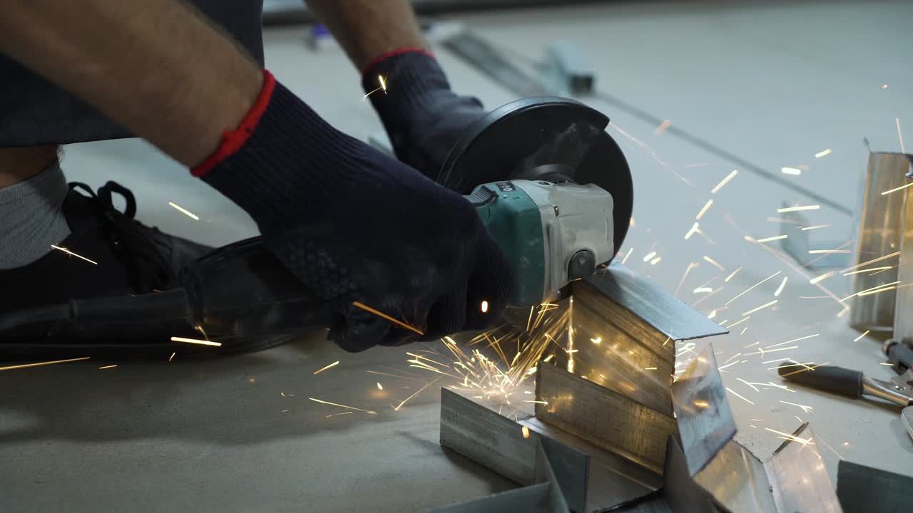 primer plano de las chispas de la máquina de molienda circular que corta perfiles metálicos en el taller