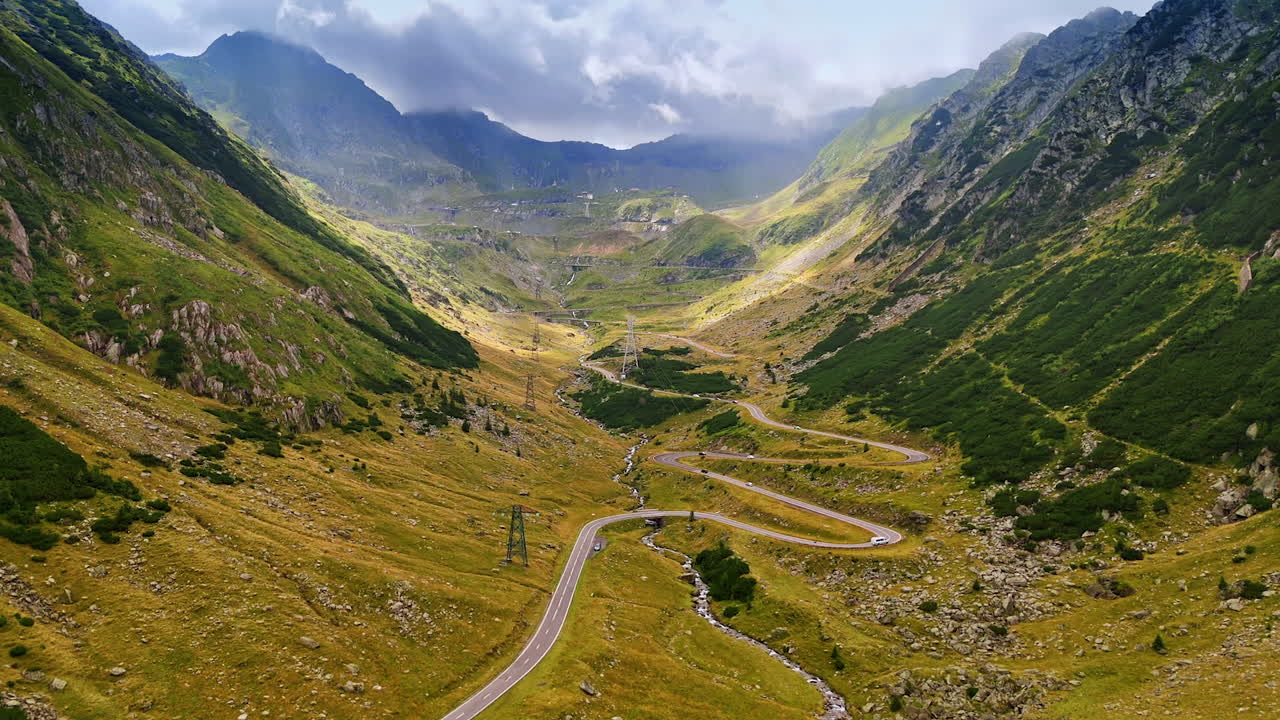 Stunning Transfagarash highway in the Carpathian Mountains, Romania. Dramatic clouds cover the rocks at backdrop