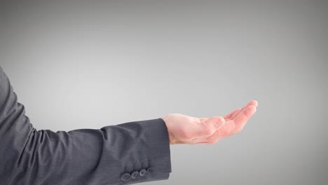 Businessman&#039;s hand with palm up dressed in grey suit on grey background
