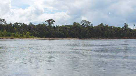 Pasando-Por-El-Río-Tambopata-Durante-El-Día-Con-Un-Cielo-Y-Una-Selva-Asombrosos