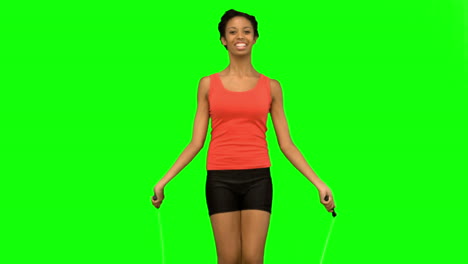 cheerful woman working out with a rope on green screen