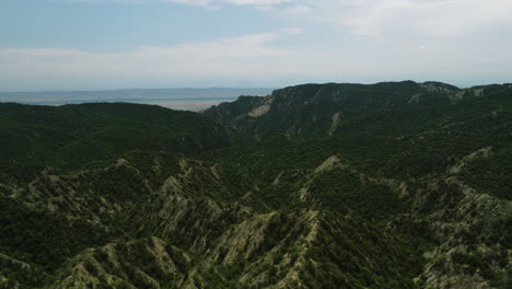 Ragged-hills-with-vegetation-beyond-cliff-with-dirt-road,-Georgia