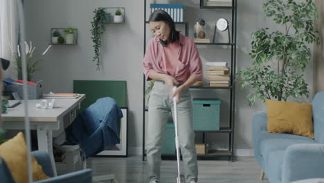 young woman cleaning her living room with a wireless vacuum