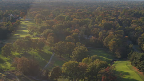 Paisaje-De-árboles-De-Otoño-Con-Campo-De-Golf-Lento-Con-Un-Destello-De-Lente