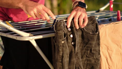 golden hour laundry: man hanging clothes on line