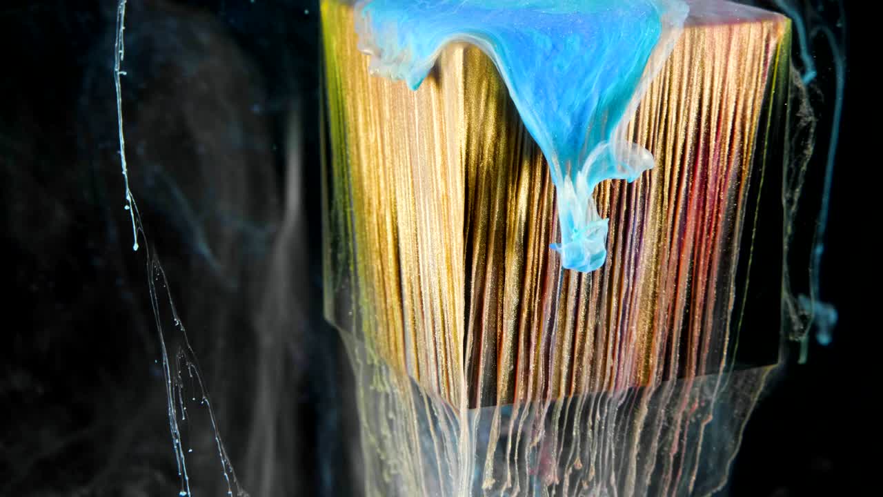 pintura de tinta multicolor fluye lentamente desde el cubo bajo el agua