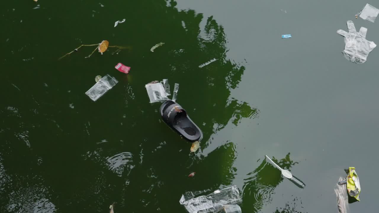 Trash on the polluted green water surface in Hanoi’s West Lake, Vietnam