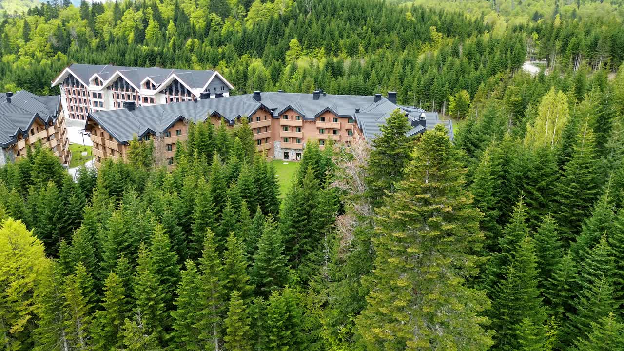 Swissotel resort in Kolasin valley surrounded by lush pine forest in summer near Biogradska Gora National Park, Aerial