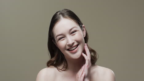 갈색 머리카락을 가진 웃는 백인 여성 얼굴을 만지는, 복사 공간, 느린 동작