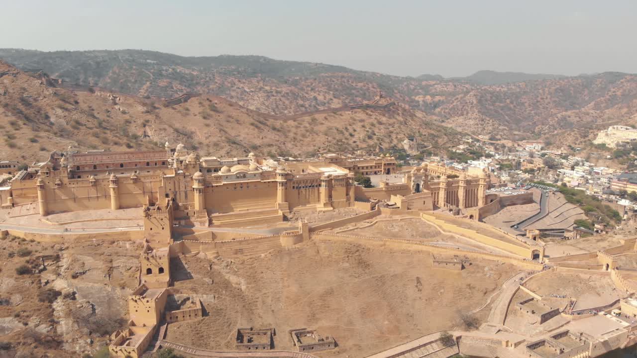 glorioso fuerte ámbar parado en una meseta en terrazas de una montaña árida en jaipur, rajasthan, india - toma panorámica aérea de órbita amplia