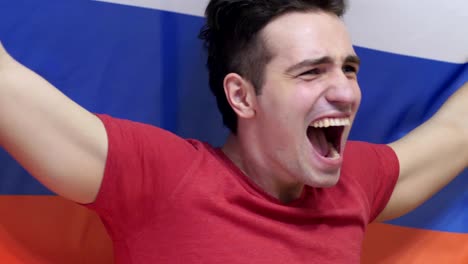 russian young man celebrating while holding the flag of russia in slow motion