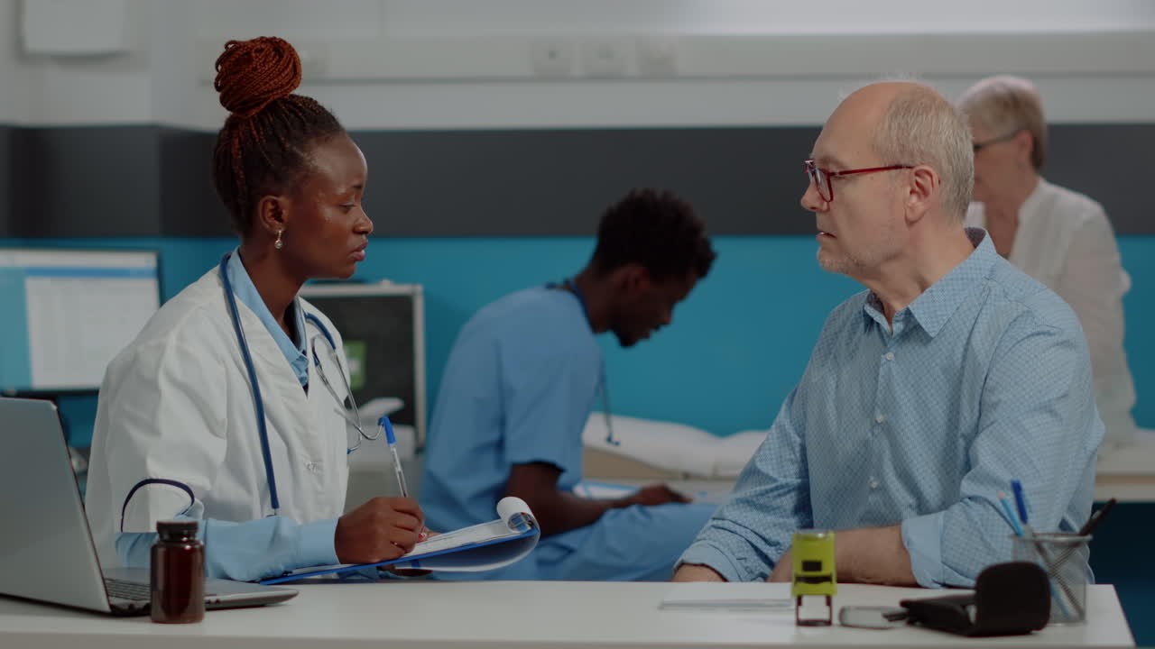 Doctor consulting with elderly patient in clinic