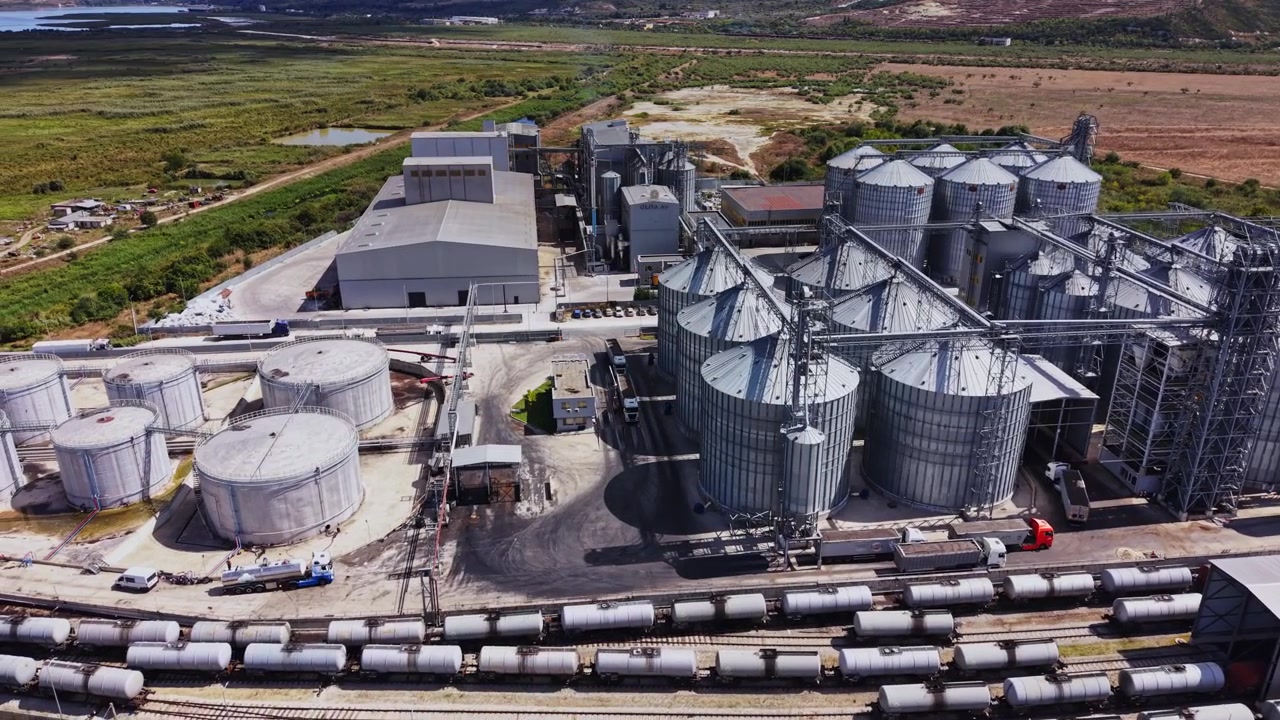 Sito industriale con silos di stoccaggio e binari ferroviari di giorno