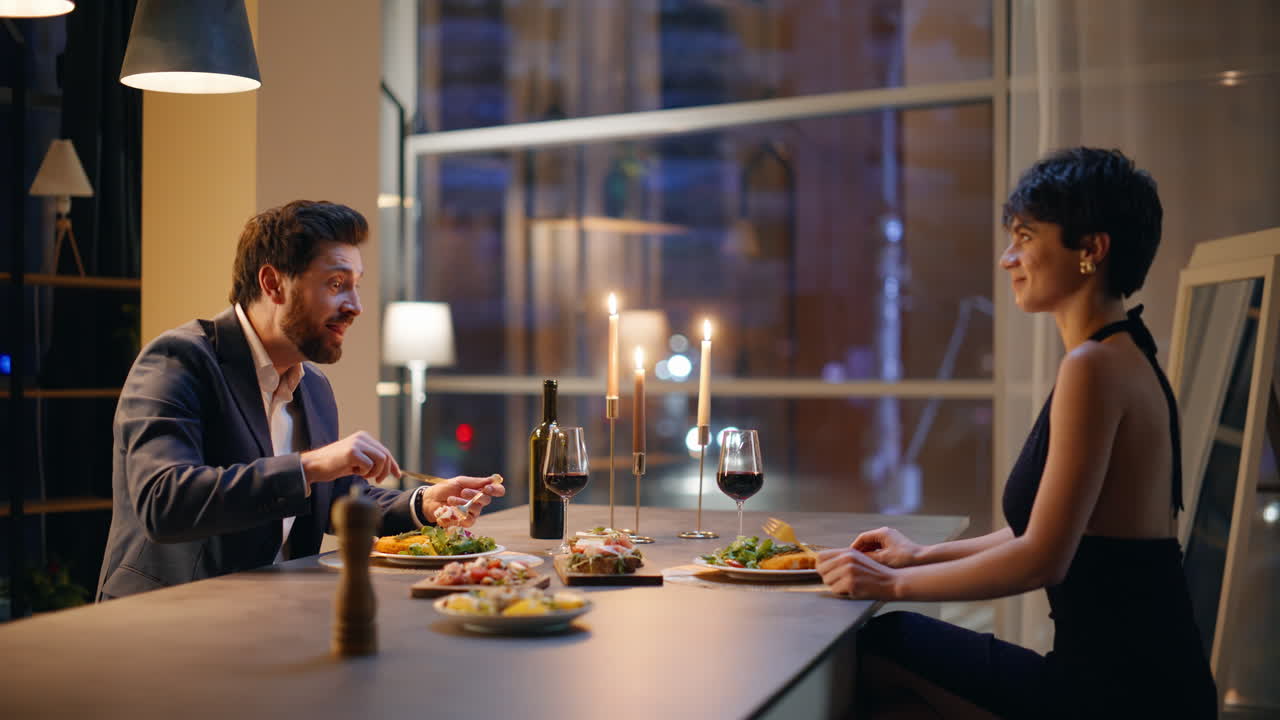 Happy pair talking romantic dinner in night cafeteria. Smiling man woman evening
