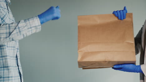 transferring the bag of food in protective gloves