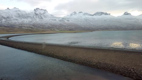 imágenes panorámicas de invierno de la carretera que conduce a lo largo de la costa del mar a las montañas volcánicas