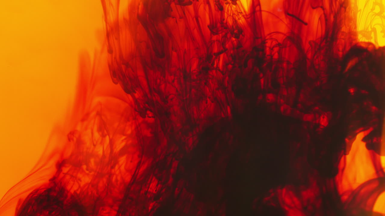 빨간색과 노란색 페인트 또는 염료가 색 배경에 물에 떨어지면 회전하는 다채로운 연기 배경을 만니다.